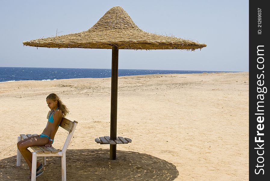 Blond girl sitting on the bench at the Red Sea Marsa Alam in Egypt