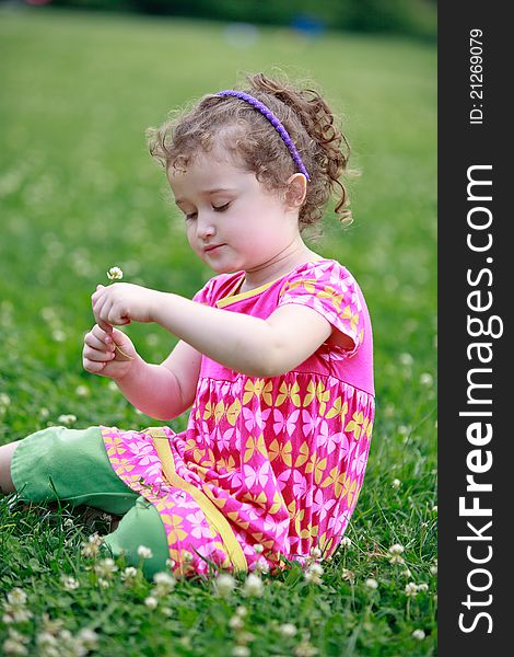 Little Girl Is Picking Flowers On Field