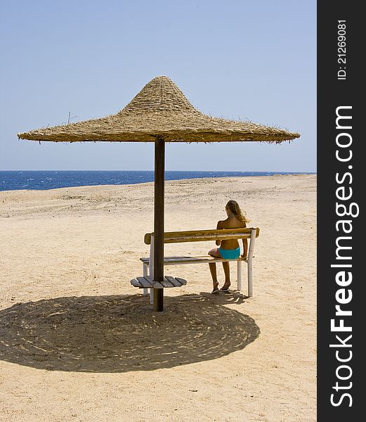 Blond girl sitting on the bench at the Red Sea Marsa Alam in Egypt