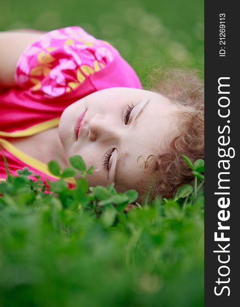 Little adorable girl lying on grass