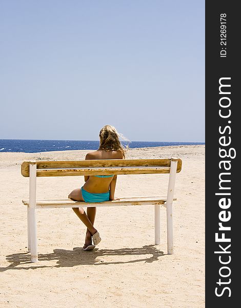 Blond girl sitting on the bench at the Red Sea Marsa Alam in Egypt