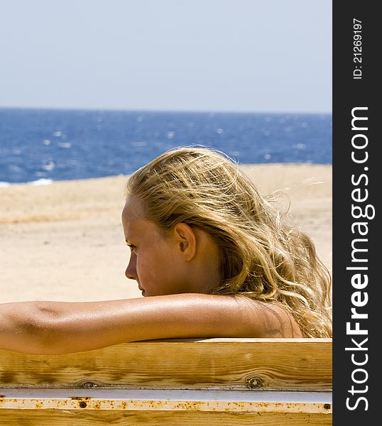 Blond girl sitting on the bench at the Red Sea Marsa Alam in Egypt