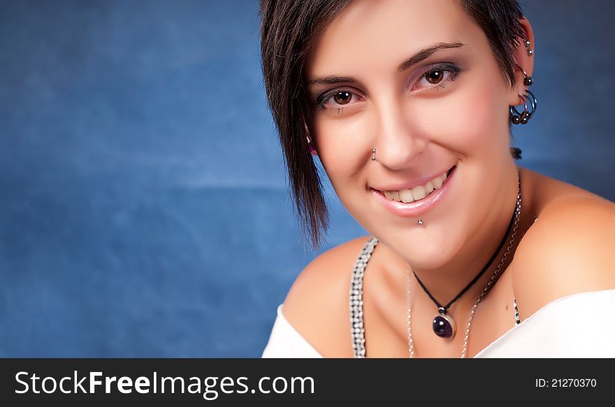 Happy brunette teenager girl with rock attitude on blue background. Happy brunette teenager girl with rock attitude on blue background