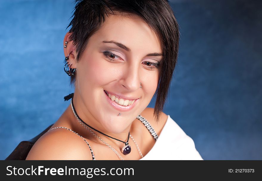 Happy brunette teenager girl with rock attitude on blue background. Happy brunette teenager girl with rock attitude on blue background