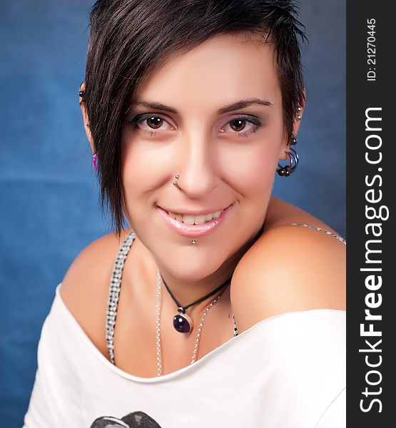 Happy brunette teenager girl with rock attitude on blue background. Happy brunette teenager girl with rock attitude on blue background