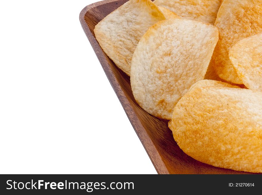 Potato chips from organic products in a wooden plate.