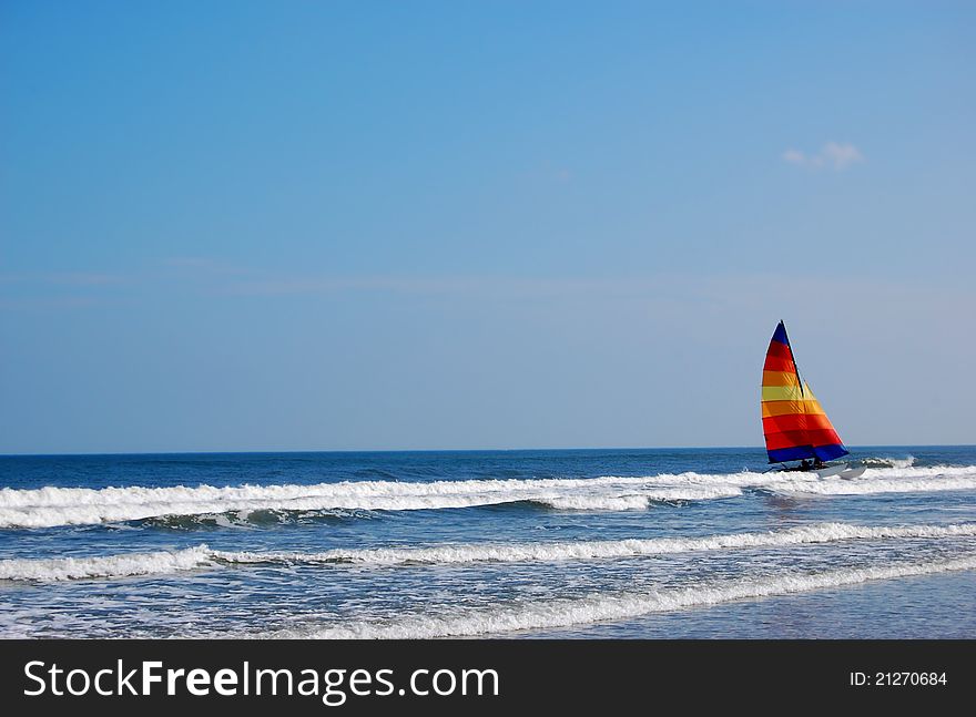 A colorful catamaran in the ocean surf. A colorful catamaran in the ocean surf