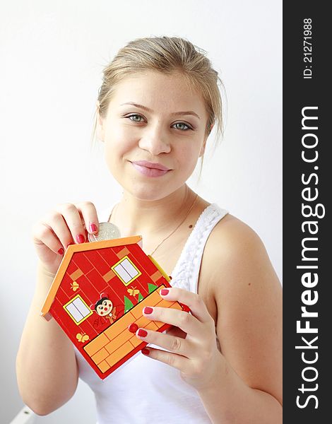 Teenage Girl Putting Coins In Her Moneybox