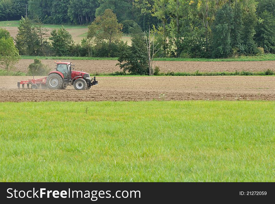 Plowing a field by a tractor harrow. Plowing a field by a tractor harrow