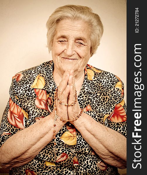 Elder woman in deep prayer.