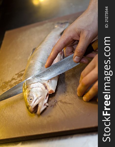 Human preparing fish with a knife