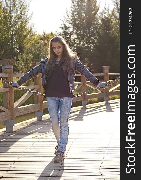 Teenage girl siting on the iron chain. Teenage girl siting on the iron chain