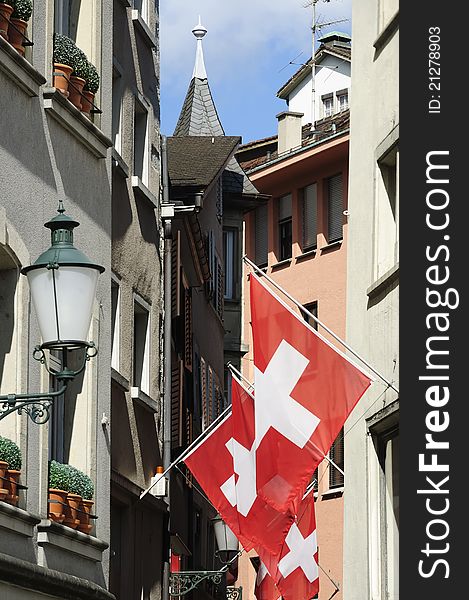 Zurich Switzerland alley in summer with Swiss flag.