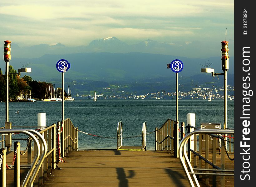 Zurich Switzerland lake pier, with Alps view.