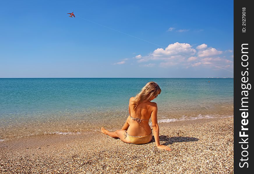 Beautiful girl relaxing on coastline of a summer beach. Beautiful girl relaxing on coastline of a summer beach