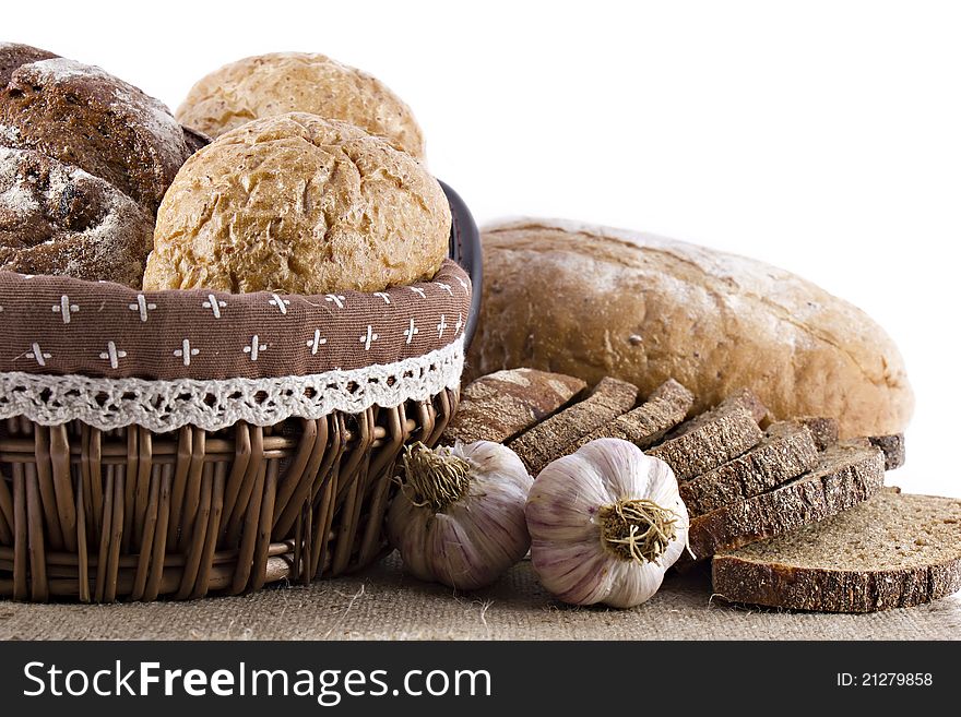 Loaves of bread and garlic over white background