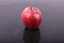 Apple On The Wet Ceramic Floor Stock Image