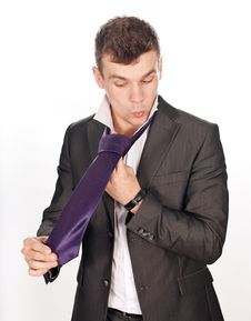 Closeup Of Businessman Tying His Tie Against White Stock Photo
