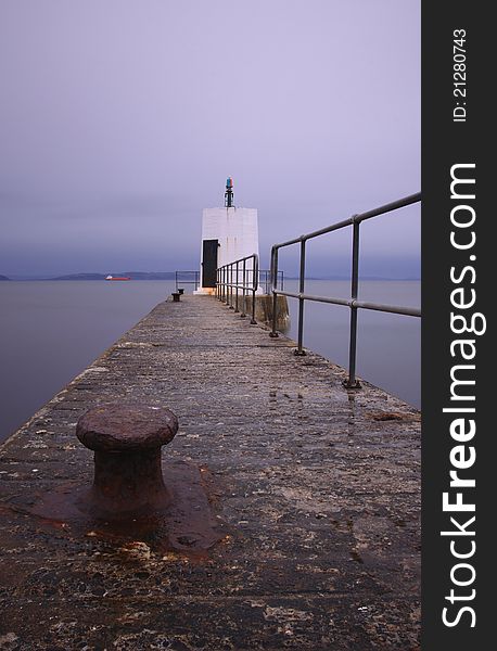 Wide angle view of Nairn pier, Highlands, Scotland, on wet day. Smooth effect on water created using slow shutter speed