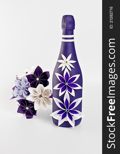 Bottle of champagne and origami artificial wedding paper bouquet - purple and white flowers with beads. Bottle of champagne and origami artificial wedding paper bouquet - purple and white flowers with beads