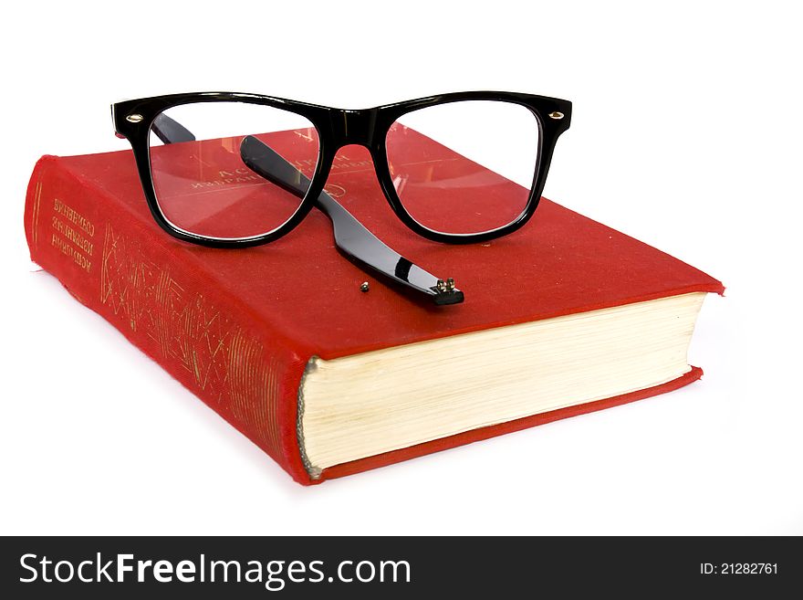 Book and glasses broken on a white background