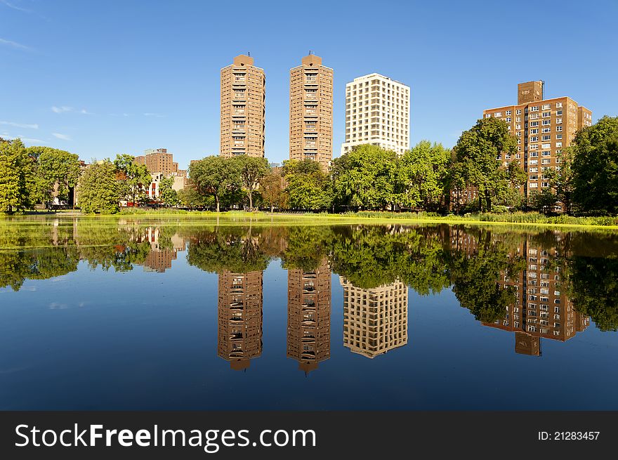 Reflections of some of the buildings and trees which surround the Harlem Meer on a Summer Day. Reflections of some of the buildings and trees which surround the Harlem Meer on a Summer Day.