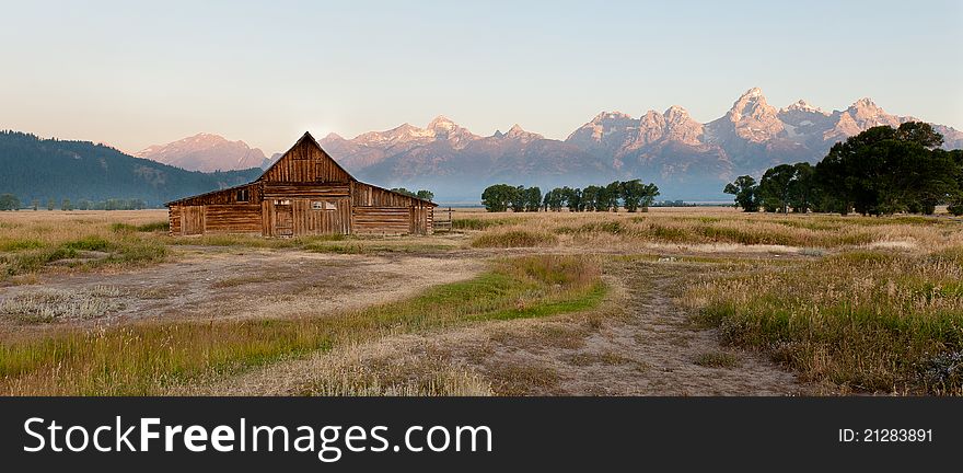 An old barn in front of the huge Grand Teton mountain range in Wyoming. An old barn in front of the huge Grand Teton mountain range in Wyoming