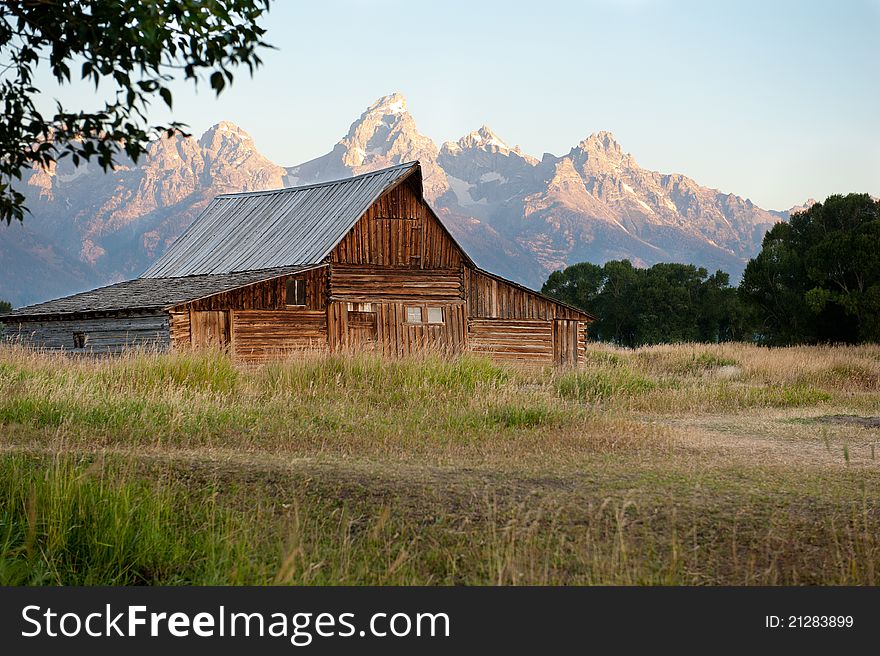 An old barn in front of the huge Grand Teton mountain range in Wyoming. An old barn in front of the huge Grand Teton mountain range in Wyoming