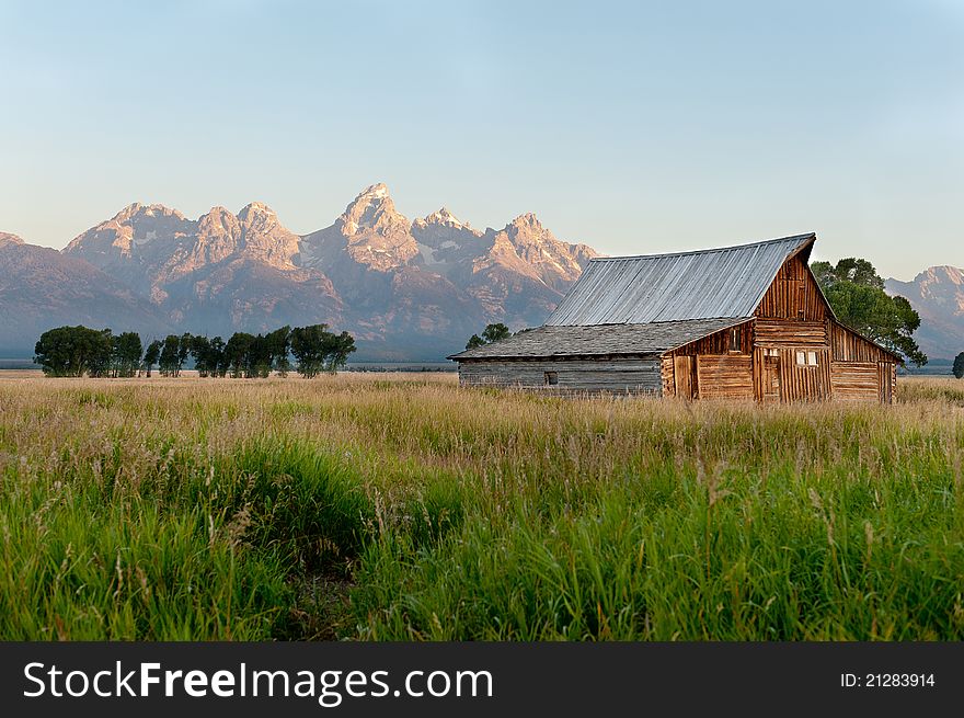 An old barn in front of the huge Grand Teton mountain range in Wyoming. An old barn in front of the huge Grand Teton mountain range in Wyoming