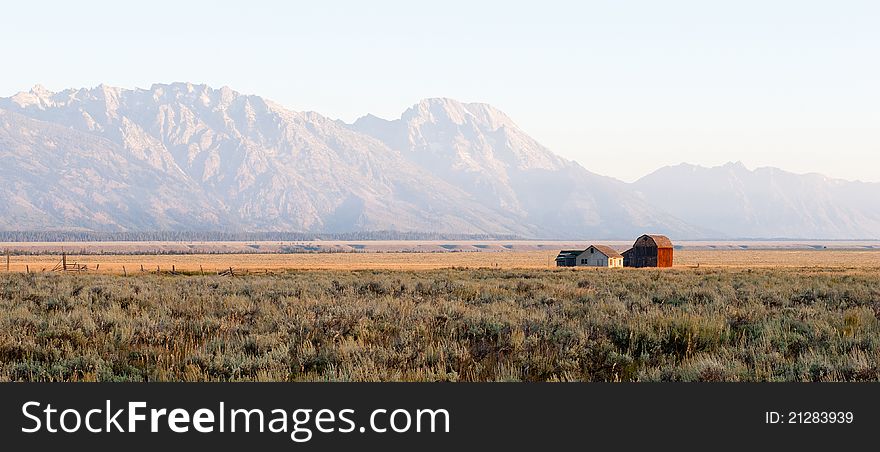 A lonely farm in front of the huge Grand Tetons mountain range. A lonely farm in front of the huge Grand Tetons mountain range