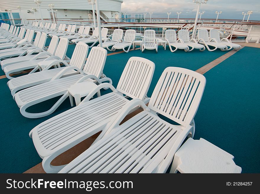 Many sun tanning beach chairs on top deck of cruise ship. Many sun tanning beach chairs on top deck of cruise ship.