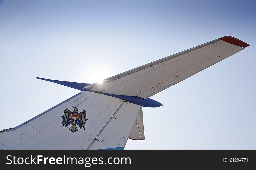 Tail part of air plane on the background of shining sun with coat of arms of Moldova. Tail part of air plane on the background of shining sun with coat of arms of Moldova