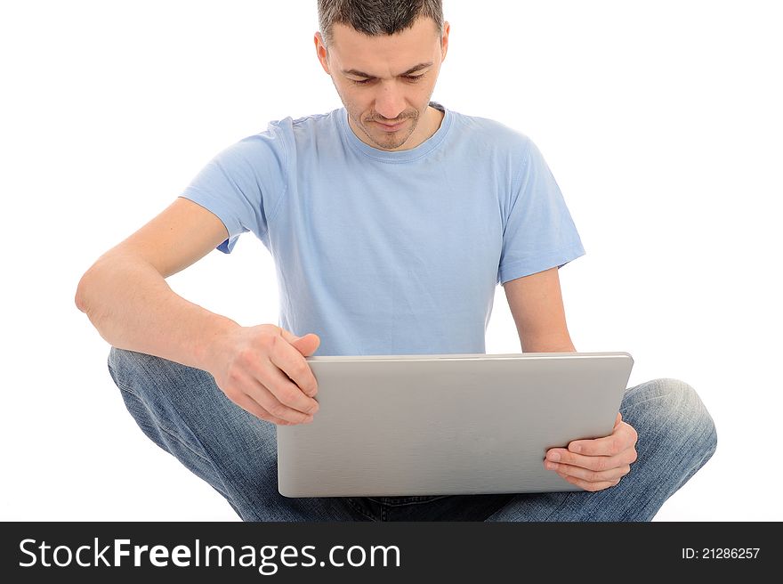 Handsome young male working on laptop computer. isolated