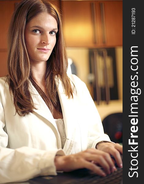 Beautiful young female doctor working on laptop in office