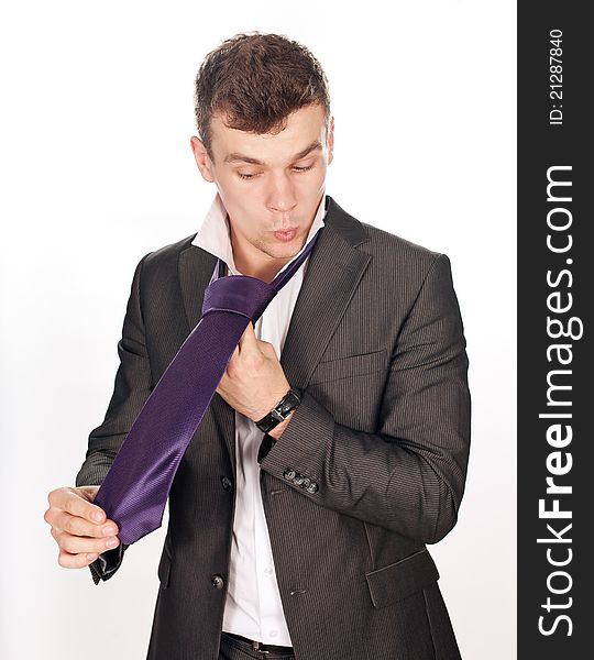 Closeup of businessman tying his tie against white background