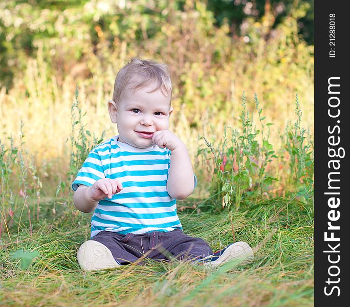 Baby sitting on grass smiling