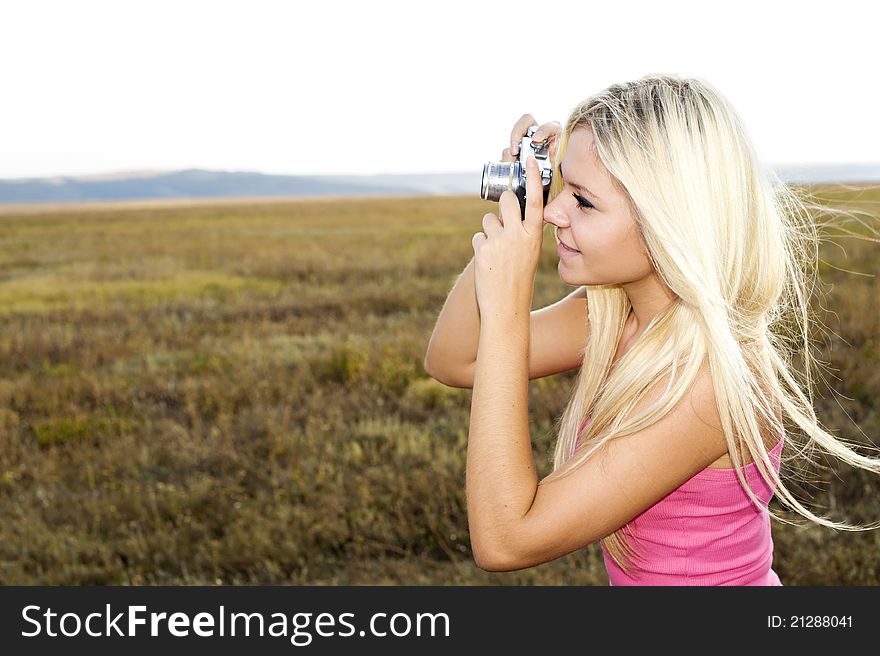 Beautiful smiling girl with camera on nature. Beautiful smiling girl with camera on nature