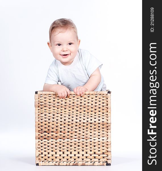 Baby boy in wicker basket on white background