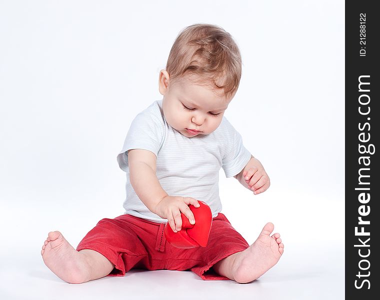 Baby playing with puzzle heart on white background