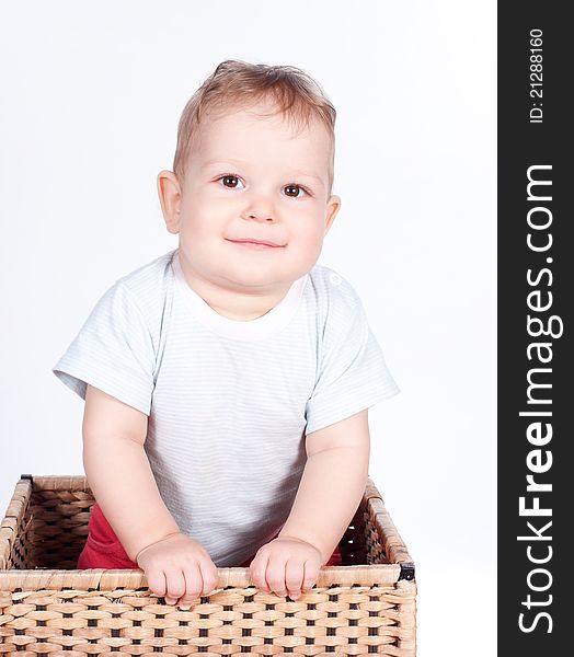 Baby boy in wicker basket on white background