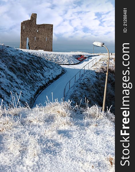 A seasonal snow covered view of atlantic ocean and ballybunion castle on a frosty snow covered winters day. A seasonal snow covered view of atlantic ocean and ballybunion castle on a frosty snow covered winters day