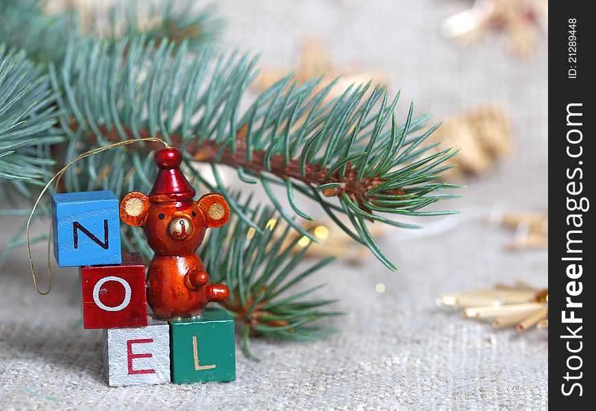 Christmas wooden ornament against a Christmas tree and a sacking