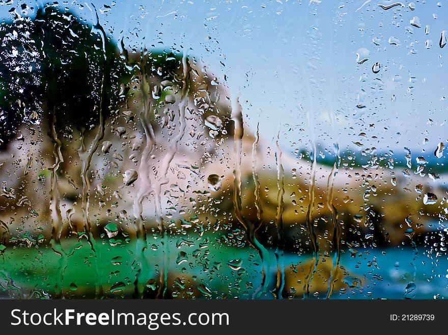 Background of sea and mountain through wet window. Background of sea and mountain through wet window