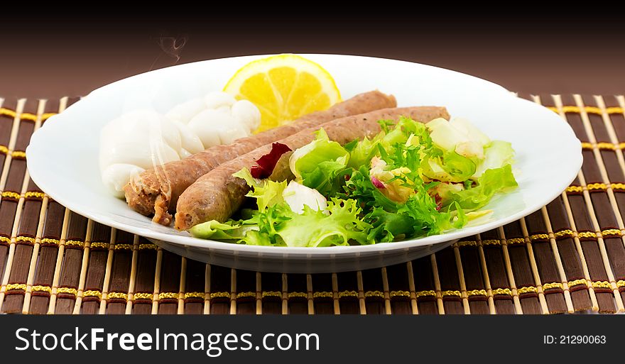 Roast sausage salad with lettuce, mozzarella cheese and a slice of lemon. Roast sausage salad with lettuce, mozzarella cheese and a slice of lemon