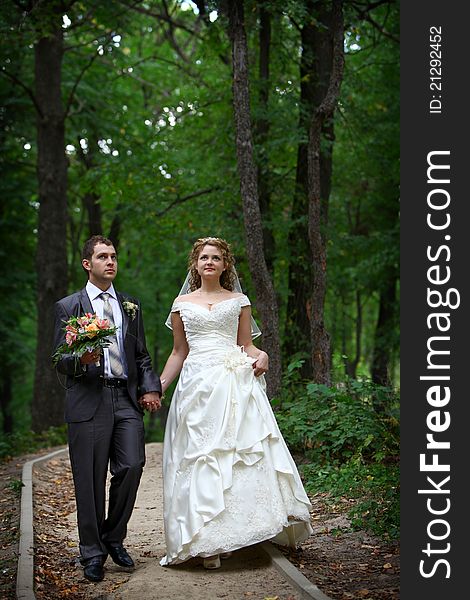 Bride and groom walking in forest