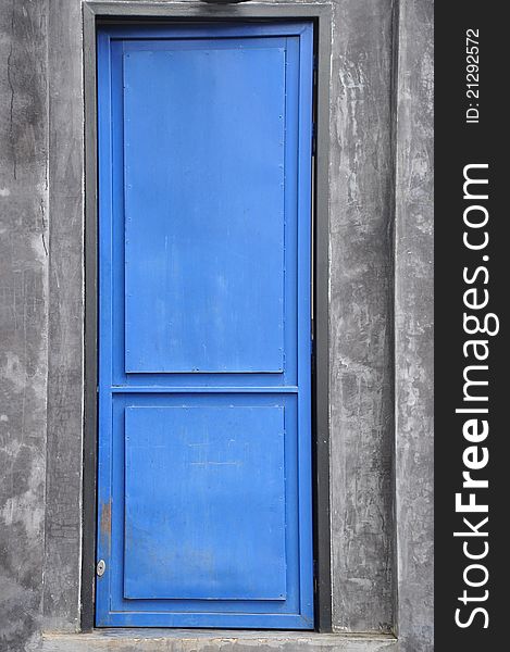 Closed blue door and grey background