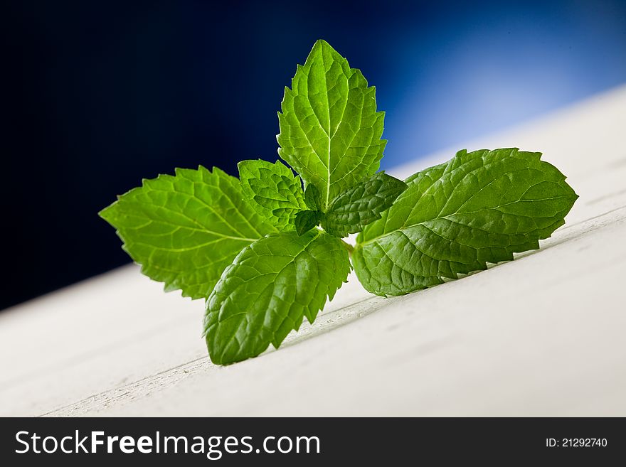 Photo of fresh mint leaves on wooden table highlighted by spot light. Photo of fresh mint leaves on wooden table highlighted by spot light