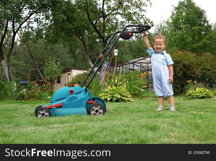 Little Boy Gardener mowing the lawn