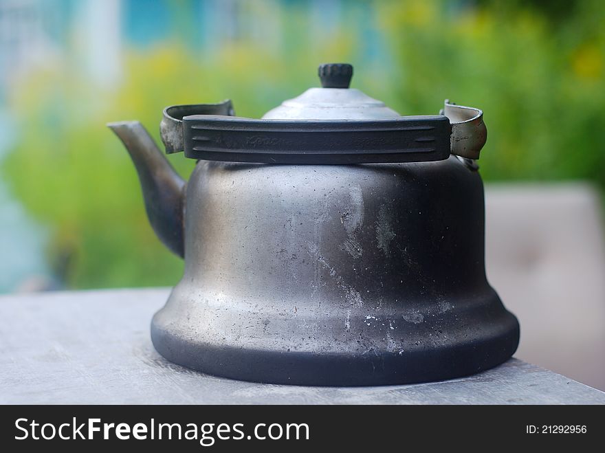 Antique dirty kettle blackened with soot. Outdoor shot, natural light, shallow dof. Antique dirty kettle blackened with soot. Outdoor shot, natural light, shallow dof