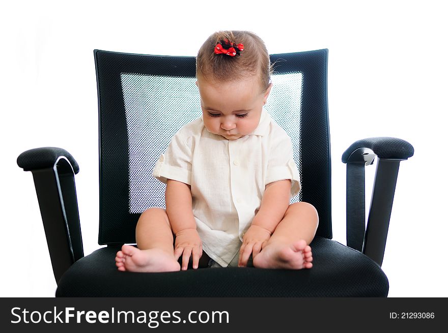 A smiling baby girl sitting in an office chair, wearing a white shirt. isolated in white. A smiling baby girl sitting in an office chair, wearing a white shirt. isolated in white